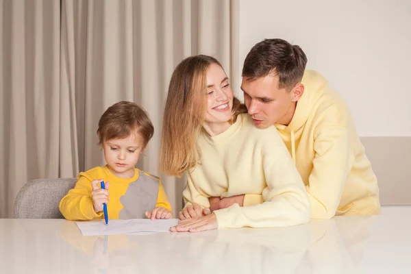 可爱的微笑的家庭 穿着黄色衣服的父母 带着儿子的画的爸爸妈妈 — 图库照片