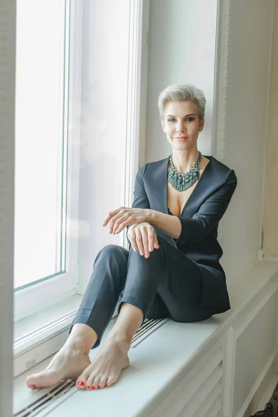Pensiv Affärskvinna Blå Kostym Sitter Fönsterbrädan — Stockfoto