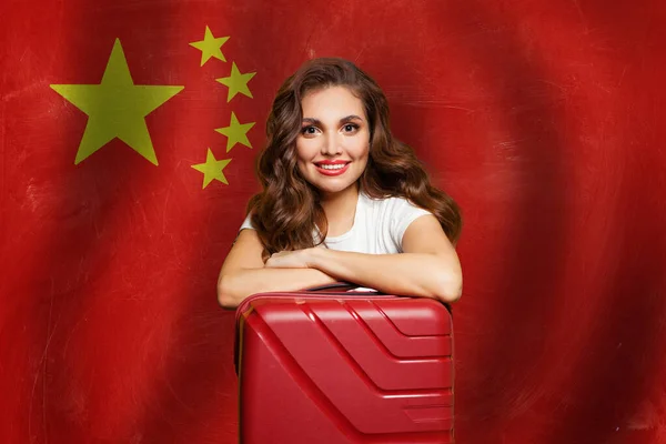 中華人民共和国の国旗を背景に赤いスーツケースを着た美しい女性 中国のコンセプトが好き 中国の旅行 インターンシップ — ストック写真