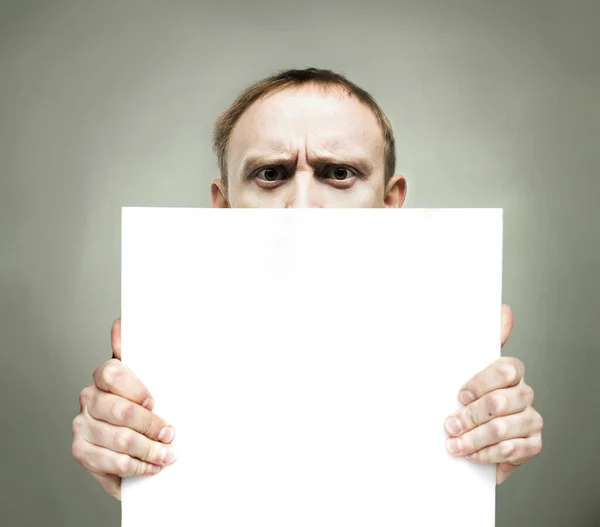 Young Frowning Man Holding Blank Sign Paper — Stock Photo, Image