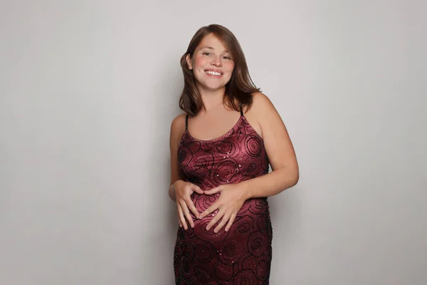 Çekici Gülümseyen Hamile Bir Kadın Gri Stüdyo Duvarının Önünde Dikilirken — Stok fotoğraf