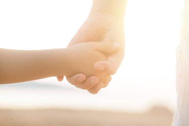 Çocuk ve ebeveyn elleri arka planda. Yardım, koruma, aile kavramı
