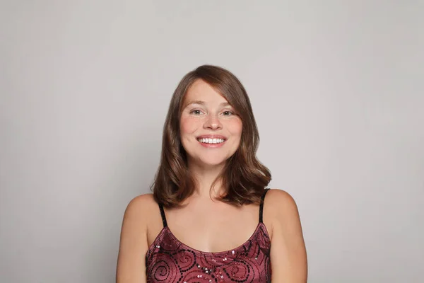 Lachende Mooie Jonge Vrouw Rode Jurk Poseren Grijze Achtergrond — Stockfoto