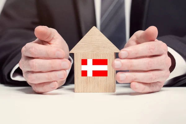 Empresário Mão Segurando Modelo Casa Madeira Com Bandeira União Dinamarquesa — Fotografia de Stock