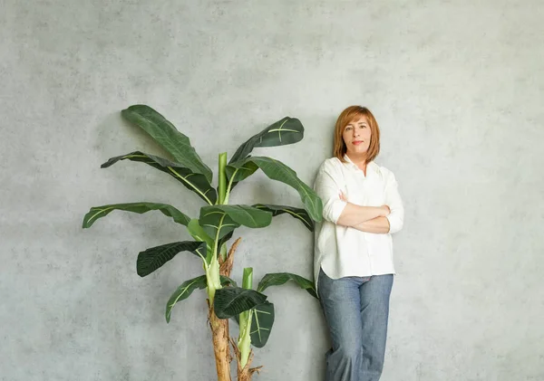 Σίγουρη Επιτυχημένη Γυναίκα Στέκεται Γκρι Φόντο Πράσινα Φύλλα Εσωτερικούς Χώρους — Φωτογραφία Αρχείου