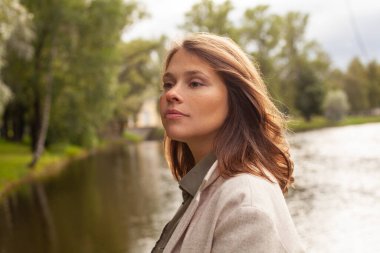 Mükemmel bir genç kadın parkta yürüyor, açık hava portresi.