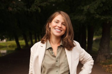 Kahverengi saçlı, mutlu, gülen kadın.