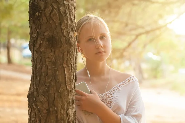 Menina Adolescente Fones Ouvido Segurando Telefone Celular Perto Árvore Fundo — Fotografia de Stock