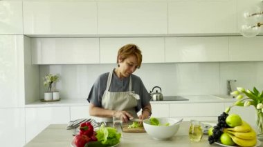 Güzel bir kadın mutfakta vegan salatası pişiriyor.. 