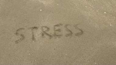 Yazılı bir sözcüğün deniz kumu üzerindeki stresinin görüntüsü. Sahildeki stresi anla.