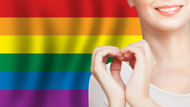 Sevmek ve LGBT insanlarına yardım etmek. LGBT arkaplanında kalp işareti yapan kadın