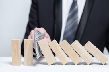 Tahta bloklar para dolarları koruması, domino, sigorta güvenlik mülkiyeti konsepti, düşmeyi bırak.