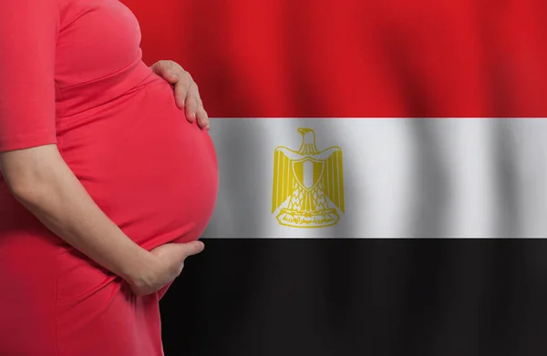 Pregnant woman belly on Egyptian flag background
