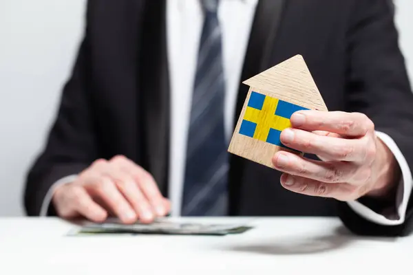 Empresário Mão Segurando Modelo Casa Madeira Com Bandeira Sueca Conceitos — Fotografia de Stock