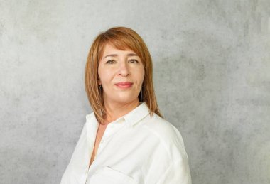 Gri arka planda mutlu başarılı kadın.