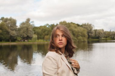 Açık havada kahverengi saçlı endişeli genç bir kadının portresi.