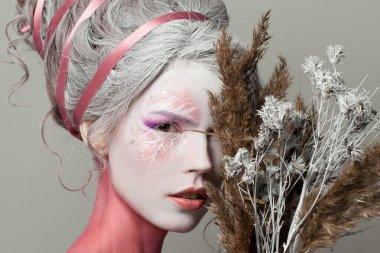 Karnaval kış makyajlı şehvetli kadın model ve karlı doğal kurutulmuş bitki.