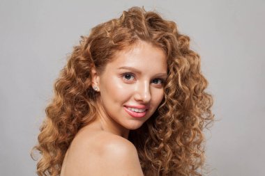 Beyaz arka planda uzun, kıvırcık kahverengi saç stili olan güzel, şık, genç bir bayan model. Dalgalı saçlı kadın
