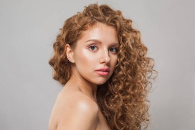 Uzun, sağlıklı, dalgalı saç stili, beyaz arka planda mükemmel temiz bir ten ve moda güzellik anlayışı olan kızıl saçlı güzel bir kadın.