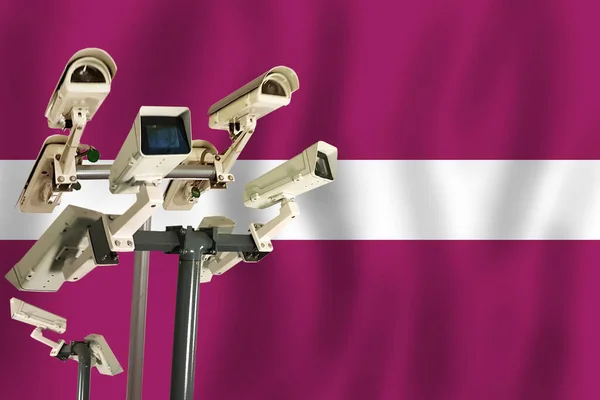 Latvian CCTV camera on the flag of  Latvia Surveillance, security, control and totalitarianism concept