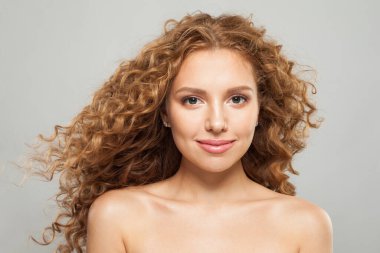 Çekici, yakışıklı, sağlıklı ciltli ve uzun dalgalı moda portresi olan genç bir kadın.