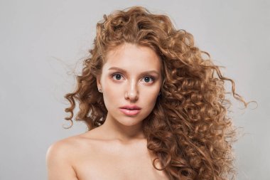 Hoş görünümlü genç bir bayan, doğal temiz, sağlıklı bir cilde ve uzun dalgalı saç stili moda portresine sahip.