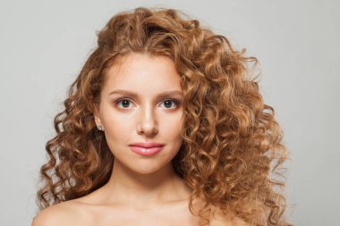 Uzun, sağlıklı, dalgalı saç stili, beyaz arka planda mükemmel temiz cilt, moda güzelliği kavramı olan muhteşem kızıl saçlı bir kadın.