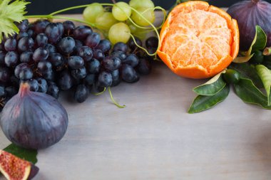 Portakal mandalinalı, incirli ve üzüm meyveli boş tahta masa. Sağlıklı gıda geçmişi