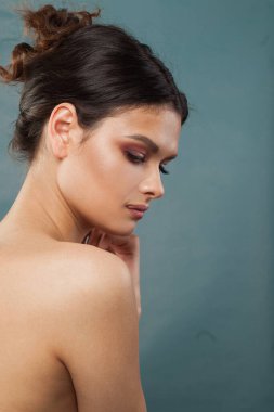 Temiz ciltli, çekici, sağlıklı bir Fenale modeli. Esmer, mavi arka planda siyah saçlı bir kadın.