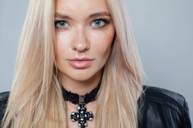 Siyah kuyumcu kolyeli, sarı saçlı güzel bir manken kadın, yakın plan portresi.