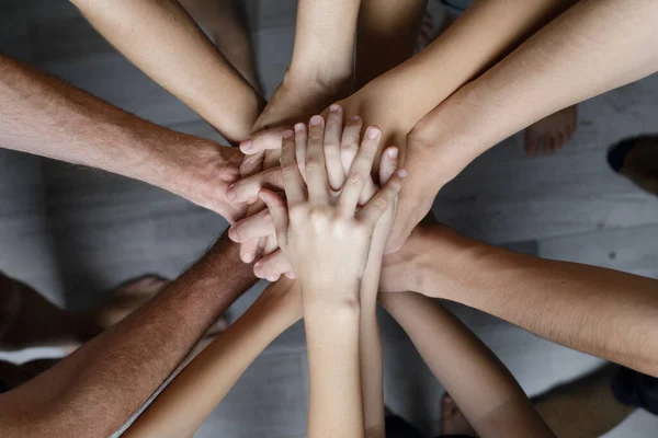 Many multiracial hands coming together as a team. Teamwork, partnership and friendship concept