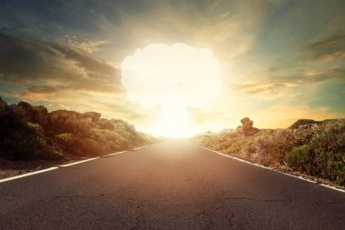 Nuclear bomb explosion. Mushroom cloud on horizon and empty decert road clipart