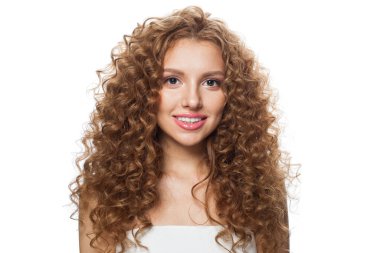 Kızıl saçlı, uzun kıvırcık saçlı ve beyaz arka planda poz veren çekici bir kadın manken. Stüdyo moda güzellik portresi