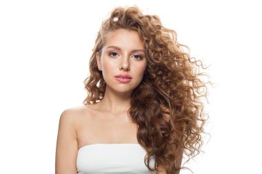 Kızıl saçlı, uzun kıvırcık saçlı ve beyaz arka planda poz veren güzel bir manken. Stüdyo moda güzellik portresi