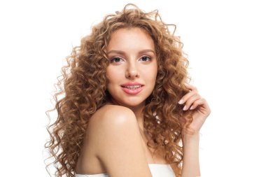 Doğal makyajlı, parlak berrak ciltli ve uzun kıvırcık saçlı, izole edilmiş sağlıklı bir model. Saç bakımı, cilt bakımı, kozmetoloji ve stil konsepti