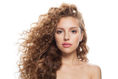 Çekici, sağlıklı, doğal makyajlı, parlak, berrak ciltli ve uzun kıvırcık saçlı bir model. Saç bakımı, cilt bakımı, kozmetoloji ve stil konsepti