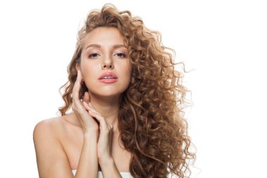 Doğal makyajlı, parlak berrak ciltli ve uzun kıvırcık saçlı çekici bir model. Saç bakımı, cilt bakımı, kozmetoloji ve stil konsepti