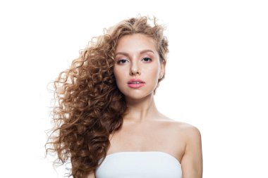 Doğal makyajlı, parlak, berrak ciltli ve uzun kıvırcık saçlı sağlıklı bir model. Saç bakımı, cilt bakımı, kozmetoloji ve stil konsepti