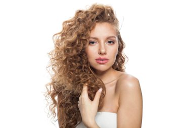 Mükemmel sağlıklı bir model, doğal makyaj, parlak berrak bir ten ve uzun kıvırcık saç stili. Saç bakımı, cilt bakımı, kozmetoloji ve stil konsepti