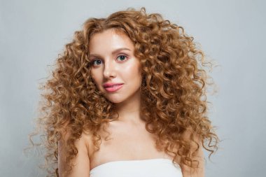 Doğal makyajlı, parlak ciltli ve uzun kıvırcık saçlı hoş, sağlıklı bir model. Saç bakımı, cilt bakımı, kozmetoloji ve stil konsepti