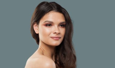 Güzel, neşeli, esmer, doğal makyajlı, sağlıklı, temiz tenli, koyu dalgalı saçlı, stüdyo moda güzellik portresi olan bir kadın. Cilt bakımı, saç bakımı ve kozmetik konsepti