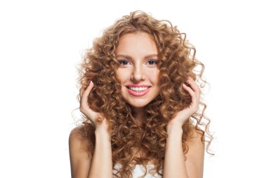 Neşeli, sağlıklı, doğal makyajlı, parlak, berrak ciltli ve uzun kıvırcık saçlı bir model. Saç bakımı, cilt bakımı, kozmetoloji ve stil konsepti