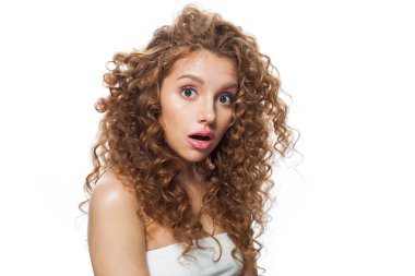 Şaşırt ve şaşırt. Güzel, sağlıklı, doğal makyajlı, parlak, berrak ciltli ve uzun kıvırcık saçlı bir model. Saç bakımı, cilt bakımı, kozmetoloji ve stil konsepti