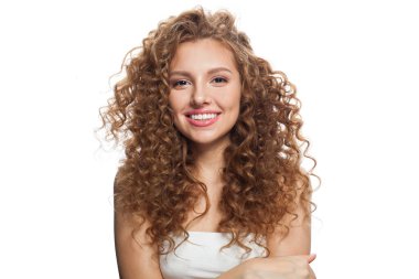 Çekici, sağlıklı bir bayan portresi. Uzun kıvırcık saçlı, doğal makyajlı ve beyaz tenli mükemmel bir kadın. Güzellik, saç şekillendirme, cilt bakımı ve estetik cerrahi konsepti.