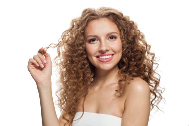 Gülen sağlıklı genç bayan portresi. Uzun kıvırcık saçlı, doğal makyajlı ve beyaz tenli mükemmel bir kadın. Güzellik, saç şekillendirme, cilt bakımı ve estetik cerrahi konsepti.