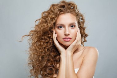 Şık, genç, sağlıklı bir bayan portresi. Uzun kıvırcık saçlı, doğal makyajlı ve beyaz tenli mükemmel bir kadın. Güzellik, saç şekillendirme, cilt bakımı ve estetik cerrahi konsepti.