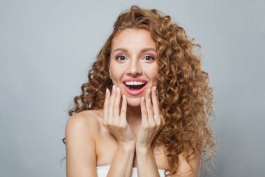 Duygusal genç, sağlıklı bir bayan portresi. Uzun kıvırcık saçlı, doğal makyajlı ve beyaz tenli mükemmel bir kadın. Güzellik, saç şekillendirme, cilt bakımı ve estetik cerrahi konsepti.