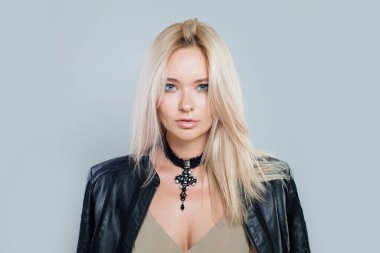 Zarif bir model kadın. Temiz tenli, sarı saçlı ve boynunda kolyesi olan bir kadın.