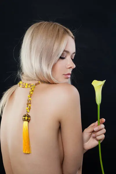 Glorious fashion jewelry model woman back. Lady with fresh clean skin, blonde hair and long necklace on her neck and body
