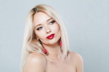 Şık bir kadın yüzü yakın plan. Taze tenli sarışın manken ve beyaz arka planda sağlıklı ipeksi saçlar. 